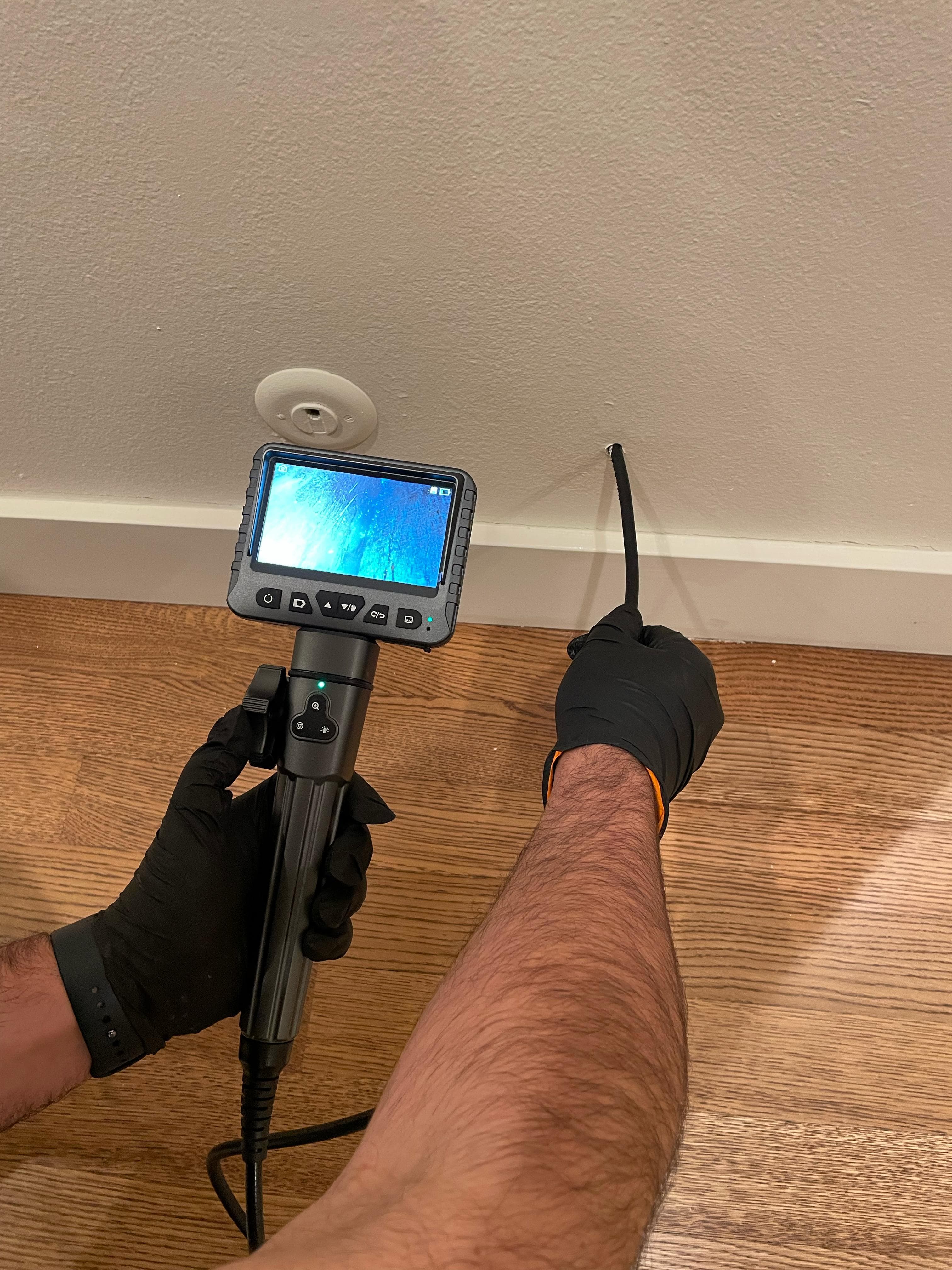 Inspector using borescope to inspect inside a wall