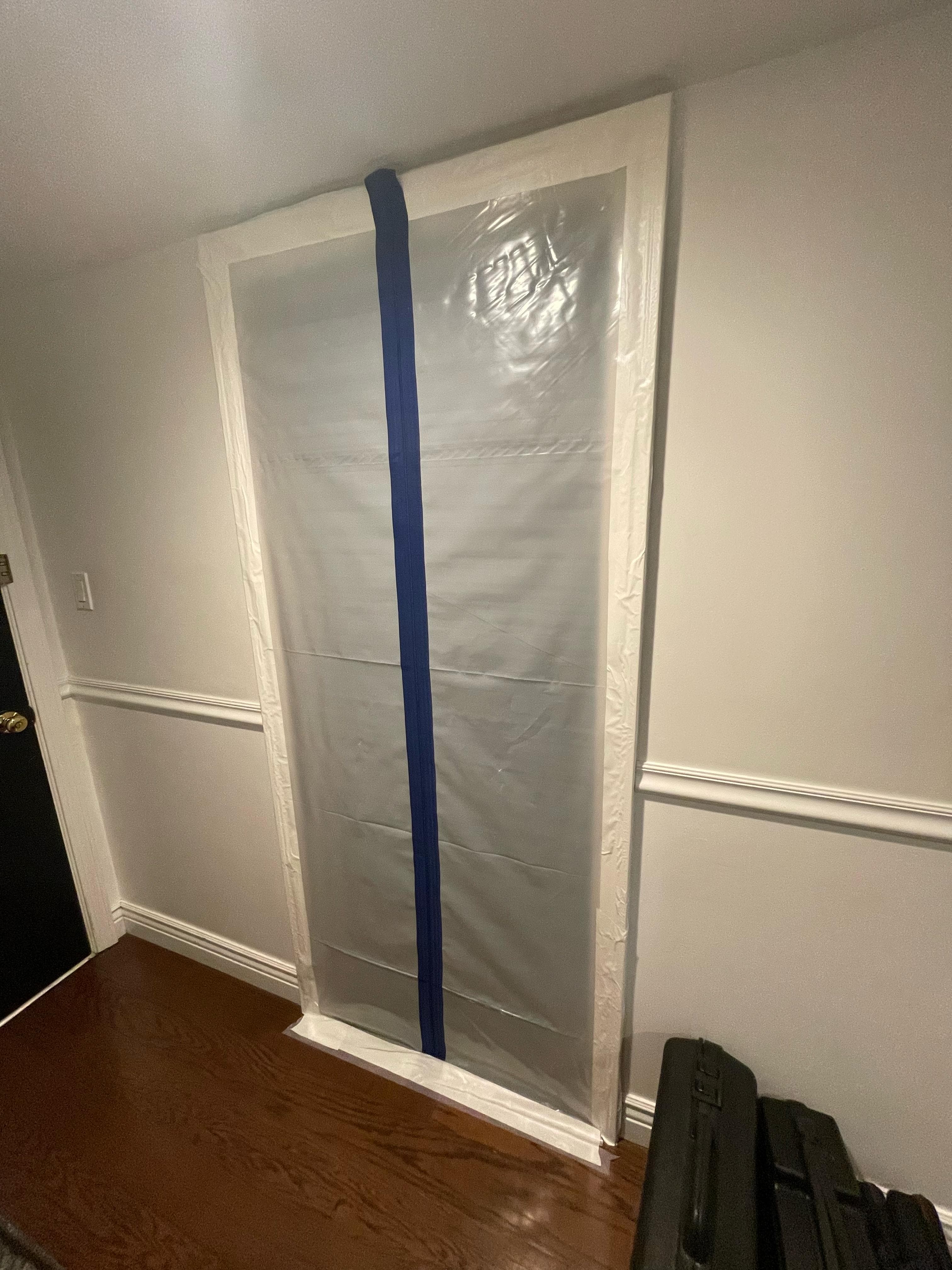 Containment barrier sealed over doorway during remediation